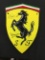 Ferrari metal shield, signedNigel Mansell CBE and Scheckter