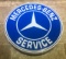 A large circular Mercedes-Benz service illuminated wall sign