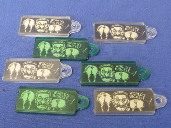 7 Vintage Plastic Key Fobs “World's Biggest” - Shows Horse & Pig Rears with a guy's face in the midd