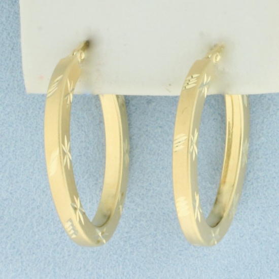 Diamond Cut Oval Hoop Earrings In 14k Yellow Gold