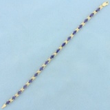 Aaa Tanzanite Flower Design Line Bracelet In 14k Yellow Gold