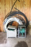 Assortment of Tubing and Garden Hoses in Holders