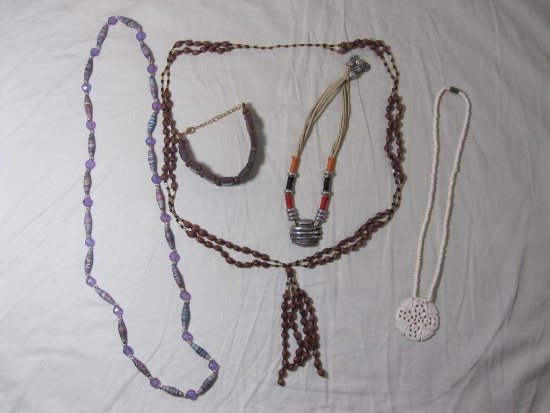 Four necklaces and a bracelet, bracelet has wood beads with footprints, corded necklace with heavy