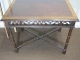 Finished solid wooden table with ornate design on side; 23