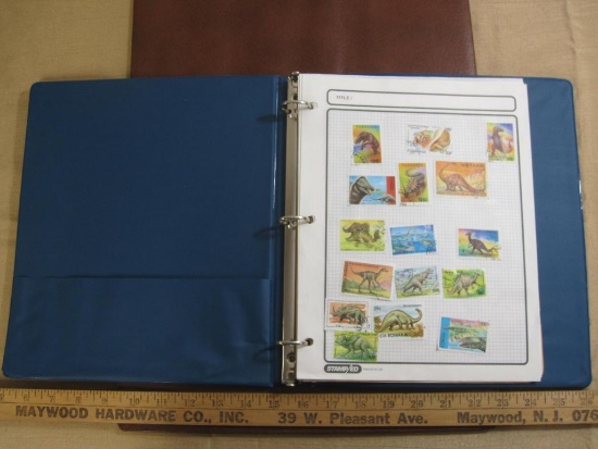 3 ring binder containing 3 pages of mounted cancelled dinosaur stamps from various countries and