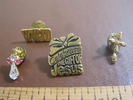 Lot of four religious pins, including WWJD, Celebrate the gift of Jesus, a cross pin and an angel
