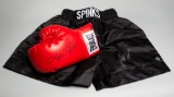 Boxing trunks and a glove signed by Leon Spinks, the black trunks inscribed