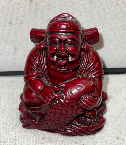 Laughing Buddhist Monk Holding fish symbolizes Good Fortune