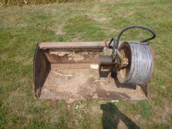 Skid loader bucket with hydraulic wire winder
