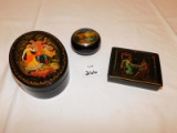 3 ENAMEL COVERED BOXES; OVAL SHAPED ONE HAS A DESIGN OF A MAN HOLDING A WOM