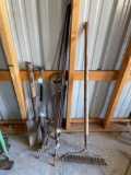 Misc. tools. Hatchet, shovel, saw, rake, posts, hammer.