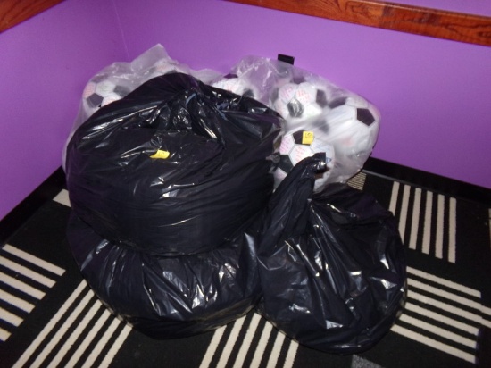 (2) Plastic Bags Of Decorative Soccer Balls & (3) Black Bags Of Curtains Or