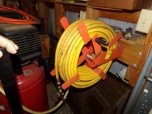 Hose Reel with Yellow Air Hose Mounted Near Air Compressor