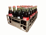 1950s Coca-Cola metal carrying case with embossed lettering.