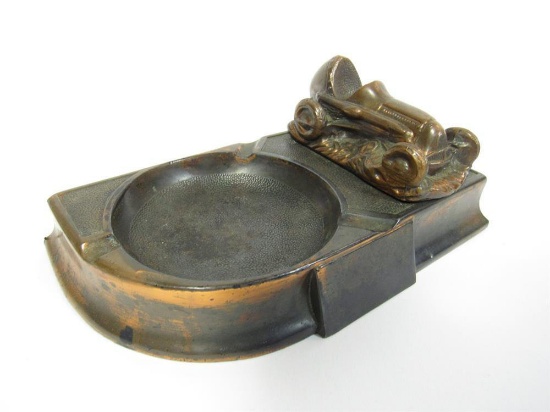Circa 1940s cast bronze ashtray with period Grand Prix racer depicted.