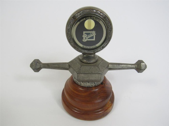 1920s Boyce Moto-Meter radiator hood mascot on dog bone. Presents with wooden base.