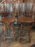 FOUR WOODEN SWIVEL BAR STOOLS WITH METAL FOOT RING,