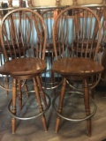 FOUR WOODEN SWIVEL BAR STOOLS WITH METAL FOOT RING,