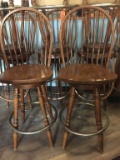 FOUR WOODEN SWIVEL BAR STOOLS WITH METAL FOOT RING,