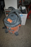RIDGID SHOP VAC AND BOXES OF HOSES AND ATTACHMENTS