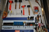 TOOLS ON WALL-MOUNTED PEGBOARD, SAWS, MALLETS,
