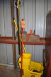 CLEANING ITEMS, BROOMS, MOP BUCKET, ETC. ON FLOOR,