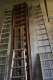 ROW OF WOODEN LADDERS, VARIOUS STYLES AND HEIGHTS