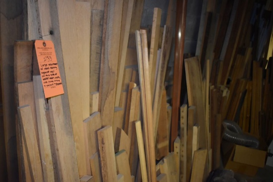 LARGE ASSORTMENT OF WOOD LEANING AGAINST WALL ON