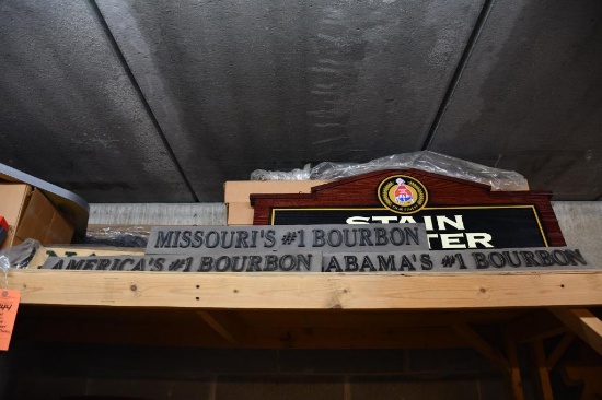 ASSORTED SIGNS ON TOP SHELF: STAIN CENTER, BOURBON, ISUZU, ETC.