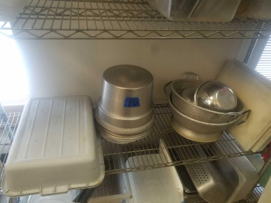 Shelf of miscellaneous sheet pans dishwasher baskets strainers and cutting boards