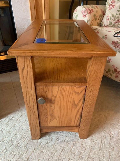 Glass top solid wood side table with door for storage.