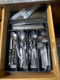 Drawer full of eating utensils knives spoons forks plus
