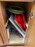 Cabinet containing cutting boards pizza pans strainers drying racks
