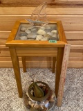 Glass top table with polished stones and a glass sailboat