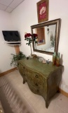 Green dresser with mirror on wall and everything in picture