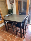 Square high table with four chairs and wall decor