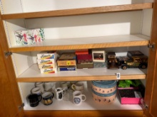 Assorted Shelf Items with Model Trucks, Mugs and Boxed Goods