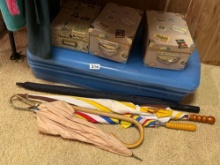 Blue Suitcase with Umbrellas and Boxed Items