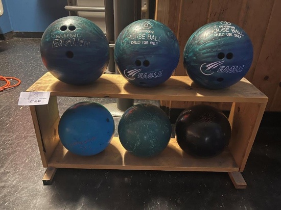 SIX BOWLING BALLS AND WOOD BOWLING BALL RACK