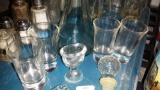 4 shot glasses, 1 glass eye wash, 2 Glass stoppers, 1 Tall Glass Oil Bottle