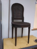 Antique black painted caned seat and back dining chair with carved flower accents