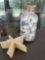 Apothecary jar with sea glass and shells, and stack of starfish decor