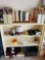 Contents of small bookshelf including books magazines and useful household items