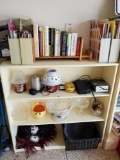 Contents of small bookshelf including books magazines and useful household items