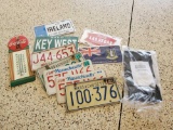 Collection of license plates including Sealed, vintage, and Coca-Cola thermometer