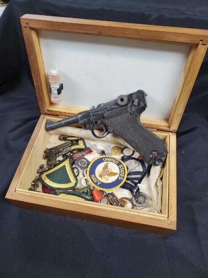 Vintage antique military style sidearm with other military items in wooden humidor