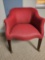 Nice red upholstered barrel chair on rolling casters.