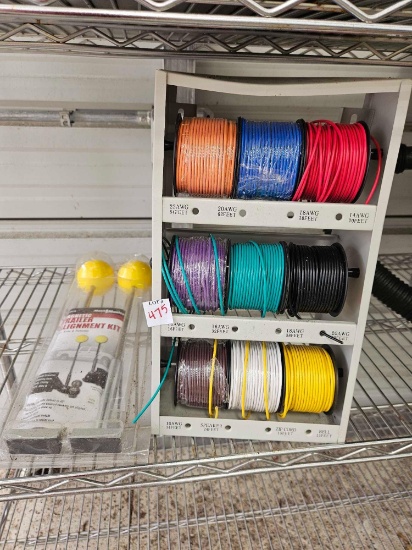 wire spool organizer filled with various gauges of electrical wire and a TRAILER ALIGNMENT KIT