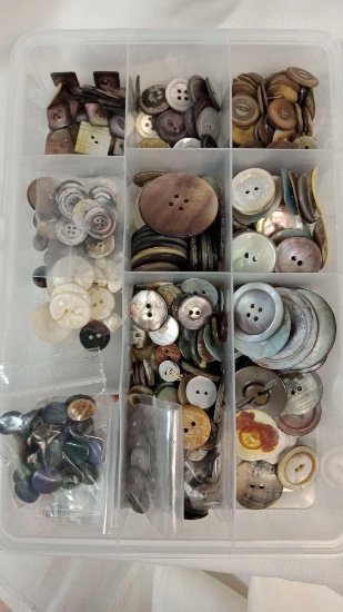 Vintage buttons, primarily appearing to be made from mother-of-pearl or similar shell materials in a