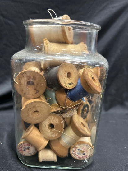 Vintage Glass jar filled with wooden thread spools including Coats and Clark's